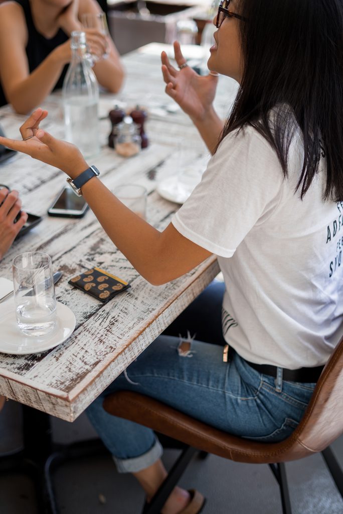 An image of a person at a table sharing a story.